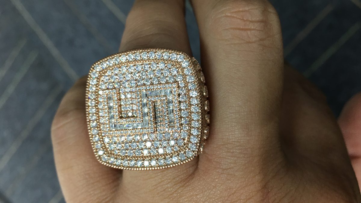 Iced-out moissanite ring worn on a finger, dense hand-set stones visible in daylight